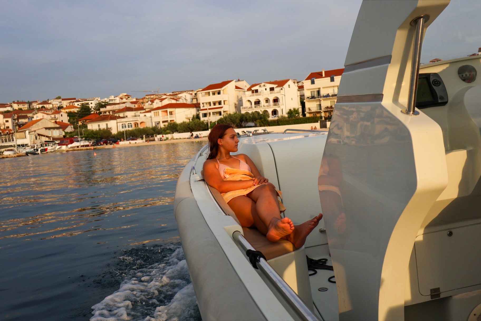 Guest relaxing on the bow seat while cruising past Okrug Gornji
