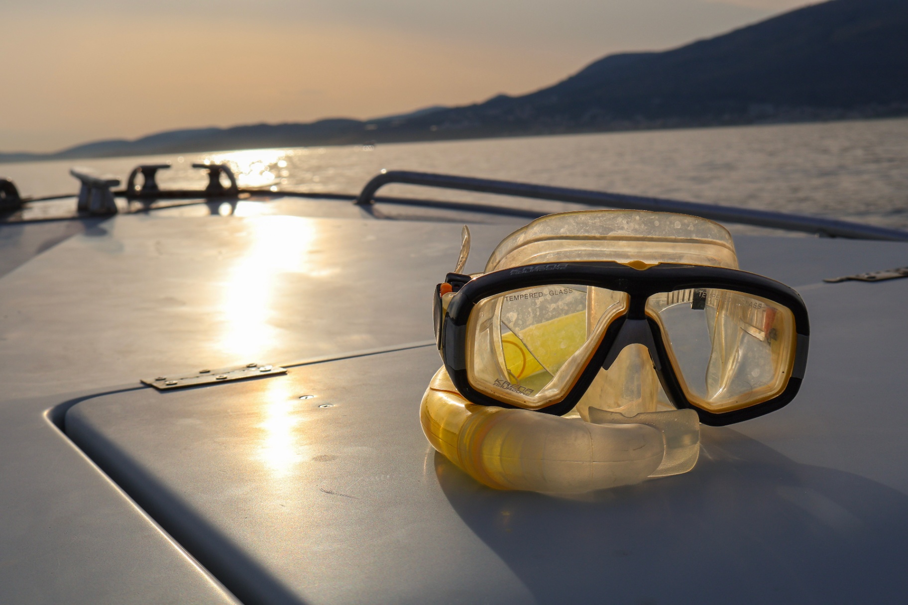 Snorkeling mask and snorkel resting on the bow at sunset