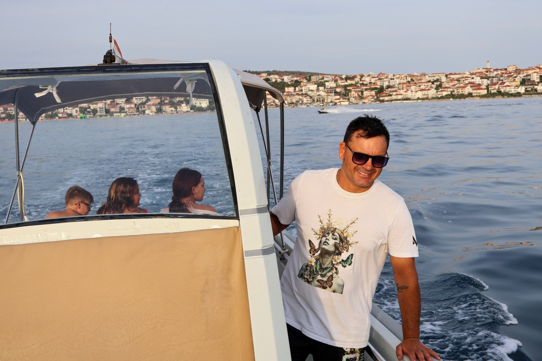 Skipper Damir smiling on board while guests enjoy the ride